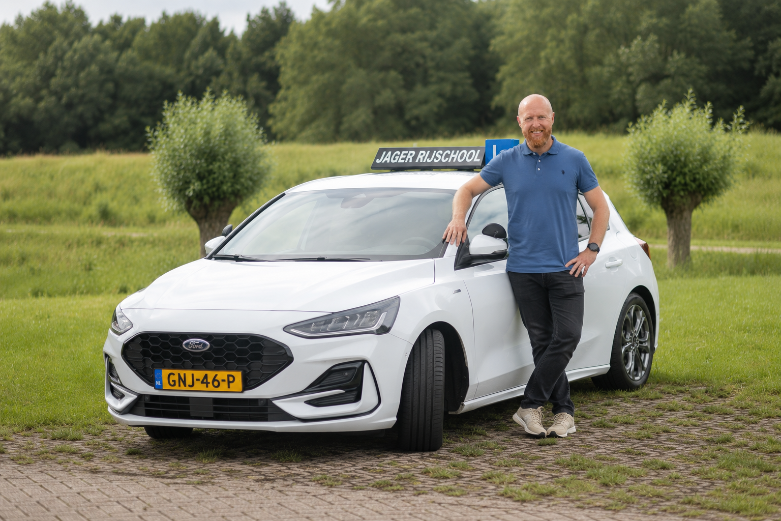 Jelle Jager standing beside the Jager Rijschool lesson car